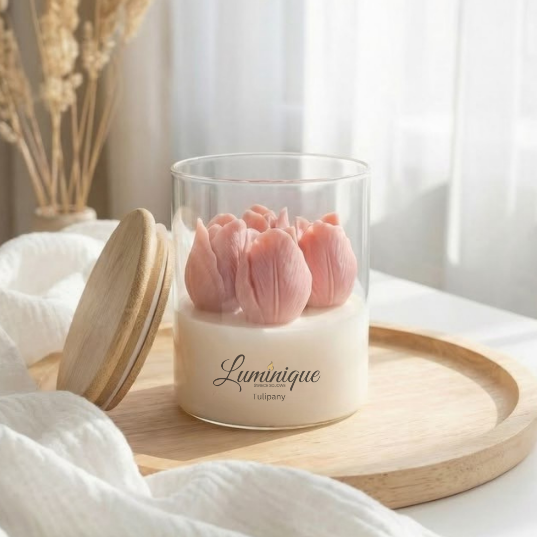 Candle with pink floral design in a glass jar on a wooden tray, with 'Luminique' branding.